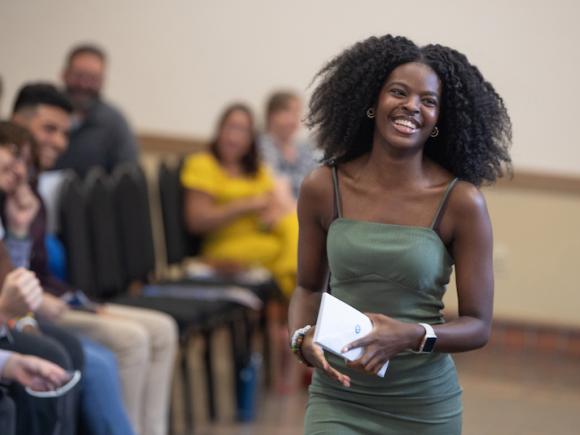 An African-American young woman smiles as she receives her certification at the Urban Education Summer Bridge Program.
